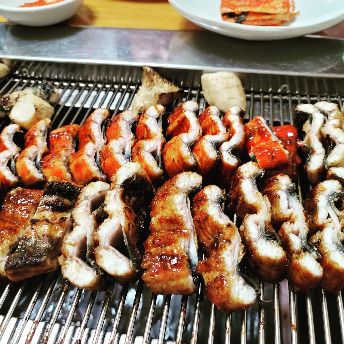 #중복 #보양식

한국식 장어구이와 장어탕, 수유동 백년가게 장어집

삼계탕 만큼이나 보양으로 빠지지 않는게 장어다

요즘은 워낙 히츠마부시나 우나기동이 많기도 하고,
혹은 마트에서 원물을 많이 팔다보니
상대적으로 가격대가 좀 있는,
어릴적 먹던 한국식? 장어구이를 자주 접하기는 힘든데,
잘 하는 집의 소금구이나 장어탕은 여전히 매력적이다

이곳 역시 그런 곳 중에 하나
어느덧 40년 가까운 시간에, 백년가게 타이틀까지 받았다

세월을 증명하듯, 
매장 곳곳 작은곳에서 한칸 한칸 늘려간 티가 나고 
오랜기간 찾은 단골 분들도 많은 듯 싶다

함초소금구이, 비법간장구이, 마늘고추장구이 세종류에 
장어탕으로 마무리하는 구성

개인적으로 한국식 장어구이의 특징은 
통으로 초벌하고, 불 앞에서 한번 더 구워 잘라주는 덕에
그 담백하면서도 기름진 고소함과 탱탱함이 살아 있다고 본다
특히 소금구이를 먹으면 그 맛을 제대로 느낄 수 있음 ㅋ

게다가 곁들이는 다양한 장아찌류의 상큼함이 조화를 이루고,
간장과 고추장은 또 나름의 변주가 되어 계속 들어가게 만든다 ㅋ

정갈한 찬들에서 이미 음식 솜씨를 짐작했지만, 
장어육수에 된장과 고춧가루, 들깨로 맛을 낸 장어탕은
그 깊은 맛이,, 몸을 후끈하게 만듬 ㅋ
 
좋아하는 누군가와 함께하고 싶은, 꽤 괜찮은 곳이다

#수유맛집 #4.19맛집 #장어구이 #장어탕 
#섬진강민물장어 #섬진강1984민물장어
#함초소금구이 #비법간장구이 #마늘고추장구이

#먹스타그램 #맛스타그램 #냠냠 #맛있다그램 #이후추네 #일상 #오늘뭐먹지#인스타데일리 #인스타푸드 #맛있다 #먹팔 #먹부림 #냠냠 #food #foodie #푸드스타그램 #먹스타 #맛스타 #백년가게