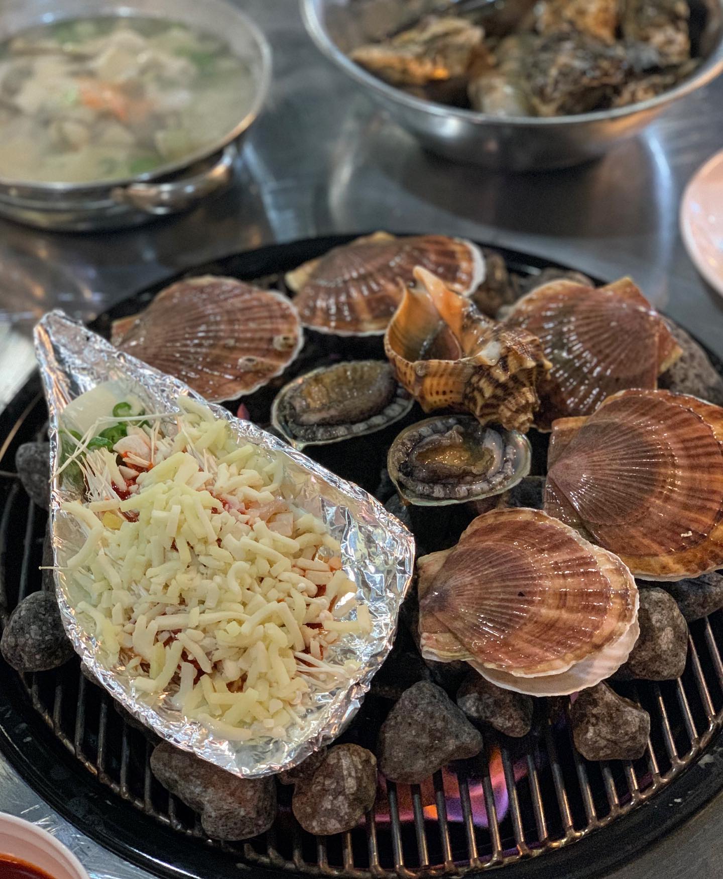 오늘 소개해드릴 곳은 서울 #교대역 에 위치한 #신상핫플레이스, 조개구이 맛집 #교대맥반석조개구이 입니다 

▪signature menu
✔모듬조개구이(55,000)
✔모듬조개찜 (55,000)
✔가리비구이 (55,000)
✔조개라면 (6,000)

맥반석에 올려진 조개가 구워지길 기다리며 은은한 조명아래에서 맥주 한 잔을 하고 있자면 마치 바닷가 바로 앞에서 조개를 구워 먹고 있는 듯한 기분이 드는 곳 #교대맥반석조개구이 

친절하고 감각있는 사장님이 오픈한 조개구이집으로 조명과 감성적인 인테리어가 매력적인 곳이다 시그니쳐메뉴는 모듬조개구이와 모듬조개찜인데, 메인메뉴를 주문하면 신선한 조개가 듬뿍 들어있는 수제비와 두부김치가 곁들임 음식으로 준비되어 구성도 알차다

매일 새벽시장에서 직접 공수한 해물만 상에 올린다는 #교대조개구이맛집 교대맥반석조개구이, 화력 좋은 맥반석에 맛있게 구워 시그니쳐소스인 치즈 퐁듀에 찍어 먹으면 조개 고유의 바다향과 치즈 그리고 초장이 어우러져 특별한 맛을 선사한다 

특히 메인요리를 먹고 주문했던 #조개라면 은 자꾸 생각이 나서 아직도 눈앞에 아른거릴 정도. 적당히 익혀진 면발과 꼬들한 조개살을 같이 먹고 있자면 오늘이 무슨 요일이든 내일은 금요일일것만 같은 행복한 기분이든다 

대화하기 편한 분위기에 감각적인 인테리어로 감성과 맛을 모두 챙긴 #교대역맛집 #맥반석조개구이 자신있게 추천합니다. 특히 이번 겨울에는 통영에서 산지 직송한 햇굴을 활용한 굴찜과 석화를 판매하고 있다고 하니 참고하시길 바래요🌲

#식탐이 #먹스타그램 #맛스타 #맛스타그램 #foodstagram #먹팔해요 #먹스타맞팔 #먹팔 #교대맛집 #교대조개구이맛집