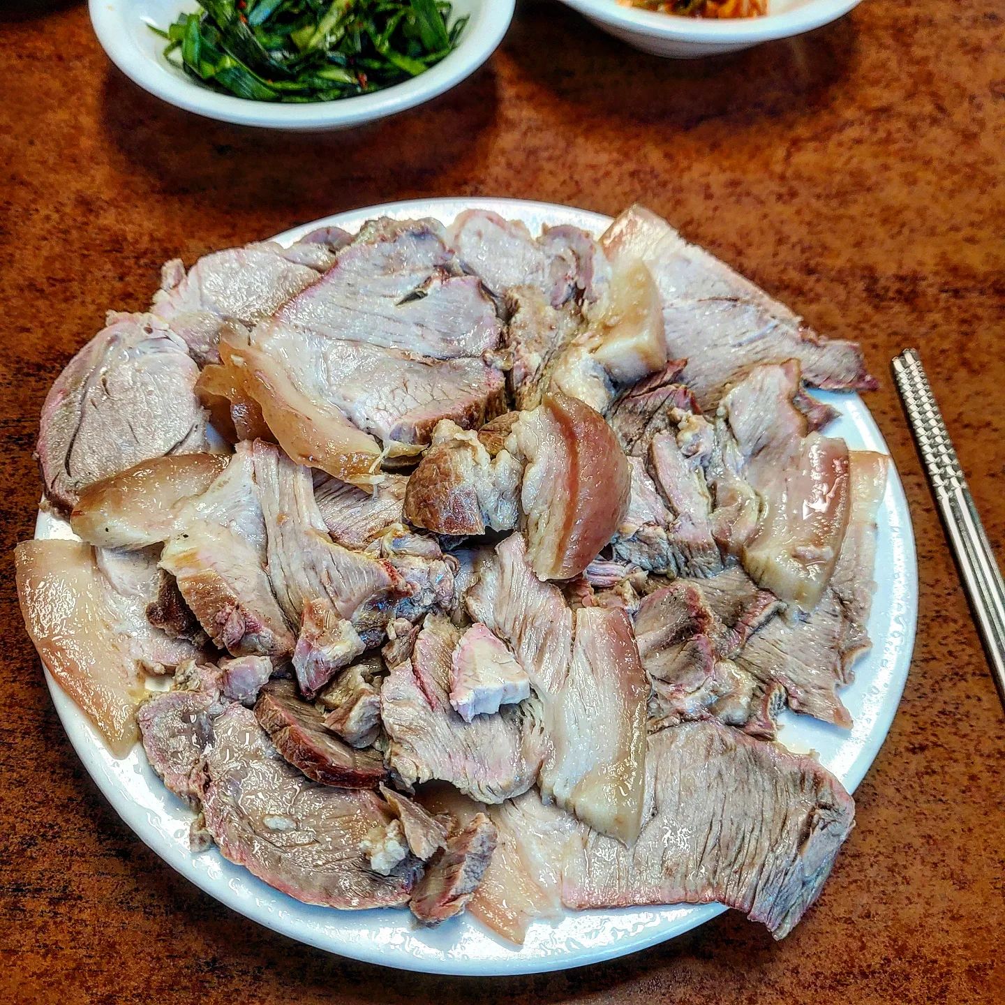 수육이 술을 부르고 나는 결국 술을 부른다. 내 얼굴은 열무국수 만큼 붉어졌다. 차를 가지고 간 것이 후회되는 곳이다.

#초량평산옥
.
부산역과 초량초등학교 사이에 위치한 100년 전통 수육 전문점 평산옥이다. 웨이팅은 없었지만 이미 많은 사람들이 들어차 있었고 마침 그 사이에 남은 한자리를 내가 차지했다.
.
메뉴는 단 세가지. 수육,국수,열무국수 뿐이다. 고르는데 10초도 안걸린다. 수육이 먼저 나오는데 한접시 씩 나오는 양을 보자니 아 이거 큰일났다. 차를 가져오는게 아닌데 하는 생각이 가장 먼저 든다.
.
잘 삶아진 수육은 언제나 옳다. 반찬없이 수육을 먼저 먹어보니 아주 기가막히게 삶았다. 껍데기와 지방은 쫀득하게 착착 감기고 살코기는 마치 나를 가지고 노는 듯 했다. 미소가 지어진다. 수육을 얼마나 잘 삶았는지 주방에 박차고 들어가 비법을 물어보고 싶을 정도이다.
.
열무국수는 수육으로 느끼해지는 입안을 가그린 마냥 깔끔하게 정리해서 목구멍으로 넘겨준다. 살짝 매콤하면서 상큼한 열무와 딱 맞게 삶아진 소면과 개운한 국물은 다시 한번 차를 가져온 것에 대한 후회를 하게 만든다.
.
믿고 먹어보시라. 그냥 맛있다.

❗️열무국수 4,000원 / 수육 10,000원
❗️부산 동구 초량중로 26, 평산옥
❗️10:00~20:00 (일요일 정기휴무)
❗️주차불가 (인근 공영주차장 주차가능)
.
.
.
#부산 #부산맛집 #부산맛집추천 #초량맛집 #평산옥 #부산역맛집 #수육 #열무국수 #맛스타그램 #맛집스타그램 #맛집추천 #맛집 #맛집투어 #맛집탐방 #먹방스타그램 #먹스타그램 #먹스타 #먹방 #먹방투어 #먹팔 #맛팔 #food #쩡테이스티 #쩡테이스티_부산