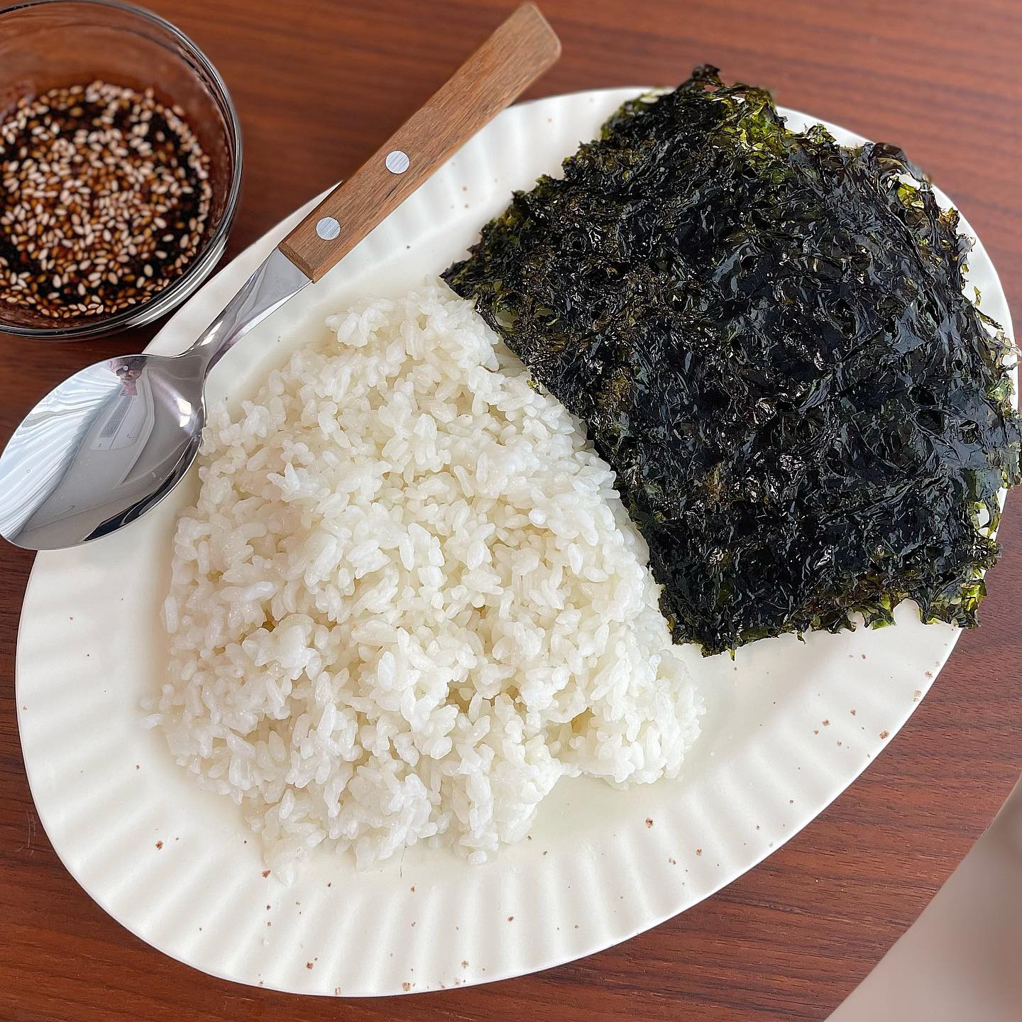 추억의 맛 보장! 이렇게 꼭 드셔보세요 #김구이 
잘 지어진 흰쌀밥에 짭쪼름한 조미김도 맛있지만,
집에서 직접 구워서 먹는 김의 맛을 따라갈 수 없죠!😋
맛있게 구운 양념김과 양념장만 있으면 밥도둑 제대로 완성!
정말 간단하지만 추억의 맛 그대로 먹을 수 있어서 정말 좋은 것 같아요❤️
오늘 밥상에 구운김 반찬 올리기 추천 드릴게요~🫶🏻

📌김구이 레시피
1. 볼에 참기름과 식용유를 1:1 비율로 넣고 잘 섞어 준비한다.
2. 넓은 쟁반에 생 김 한장을 올리고 그 위에 다시 생 김 한 장을 올려준다.
* 쟁반에 기름이 묻는 것이 방지돼요.
3. 참기름과 식용유를 섞는 기름을 손바닥에 묻혀 문지른 뒤 김에 고르게 발라준 후 소금 한꼬집을 골고루 뿌려준다.
4. 다른 김들도 같은 방법으로 반복하여 발라준다.
5. 양념김을 골고루 구워주기 위해 4등분으로 잘라준다.
6. 프라이팬을 센 불에서 달궈준 뒤 중불로 줄여준다.
7. 달궈진 프라이팬에 양념 김을 넣고 검은색 김이 짙은 초록색으로 변하면 뒤집어서 반대면도 잘 구워준다.

▫️김구이 양념
진간장3t, 쪽파2송송(선택), 들기름0.5t, 통깨조금, 고추가루 0.5t, 생수3t

#반찬 #집밥메뉴 #간식 #반찬만들기 #반찬레시피 #한그릇요리 #신혼밥상 #밥도둑