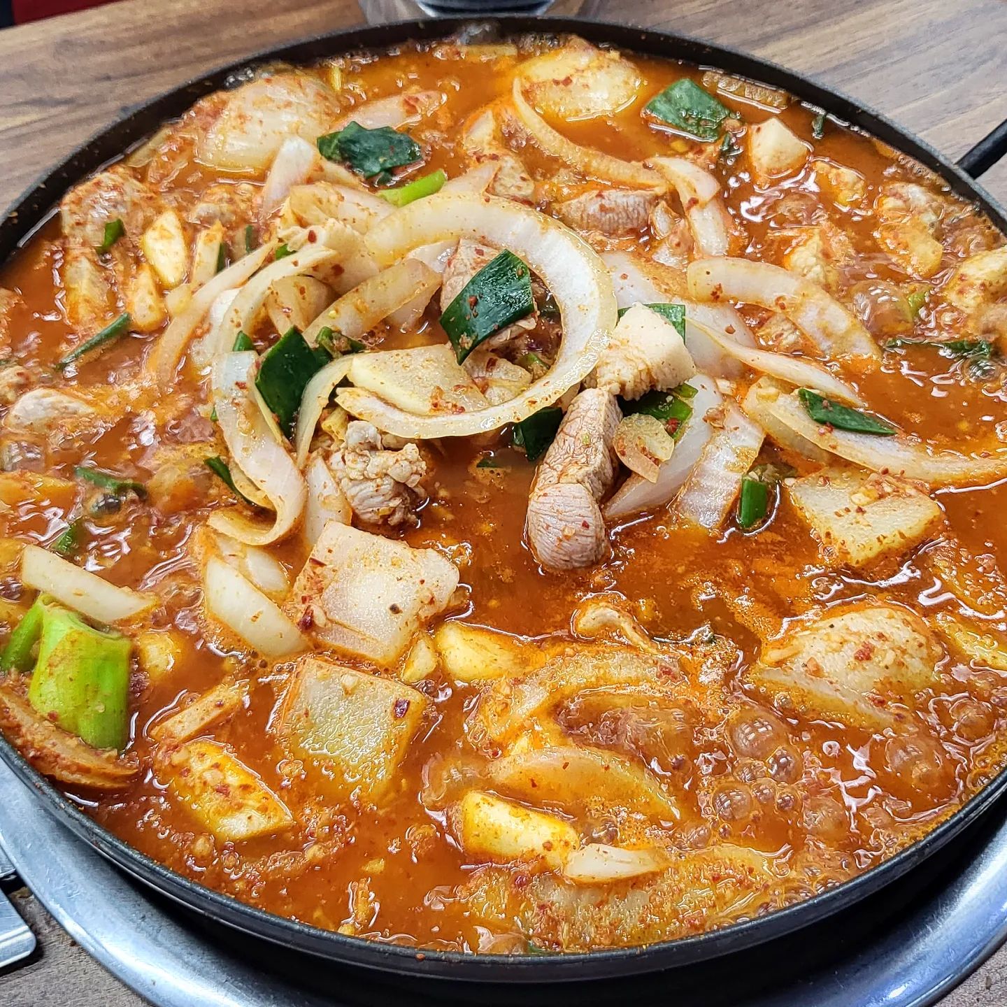 #밀양돼지찌개 #사상맛집
-
사상 간 김에 핫플이라 들린 밀양돼지찌개
저녁 시간 사람 바글바글하더라.
2인 이상 주문 가능한데
1인이 2인 주문은 안 되고
8세 이상 1인으로 치는데
8세 미만은 못 들어오는 노키즈존에
포장은 모방하는 업체들이 많다고 안된단다.
생각보다 까다로운데
어차피 어른 둘이서 먹고 갈 거라
아무 상관 없는 조건들
-
2인인데 3인이 먹어도 될 정도로 푸짐한 양에
돼지고기는 덜 익어서 끓여서 익혀 먹으란다.
가위 들고 김치 어디있냐 김치 하고 찾는데
뭐지 돼지김치찌개가 아니고 돼지찌개네
양파 반 고기 반이다.
어쩐지 나왔을 때 국물 먹었는데
볶음 같은 느낌이 났더니 김치의 부재였다.
-
끓으면서 앞치마 안 했으면 테러당했을 만한 
보글보글 공격에 놀라고
양파랑 된장만 주는 밑반찬에 더 놀람.
셀프바있길래 갔더니 땡초랑 김치는 있더라.
공깃밥 별도에 찌개 만원인데 뭔가 서운한
-
맛은 밥만 먹기 좀 아까웠다.
소주 한잔..걸쳐야..
고기양도 많은데 밥을 한 공기 다 비웠는데도
고기만 더 건져 먹었다.
무랑 마늘의 역할도 잘해주고
양파도 넉넉해 오래 끓여나온 달큰함과
비계에서 나온 녹진한 기름이랑
양념장이 어우러져서
돼지찌개의 매력이 낭낭하던 곳.
-
전용주차장이 타워라 가게앞에 주차했는데
천원 달라하셔서 지불하고
가게에서 주차비 천원 지원해주니 공짜네
-
✔️ 돼지찌개 ₩ 10,000
📍부산 사상구 광장로 20