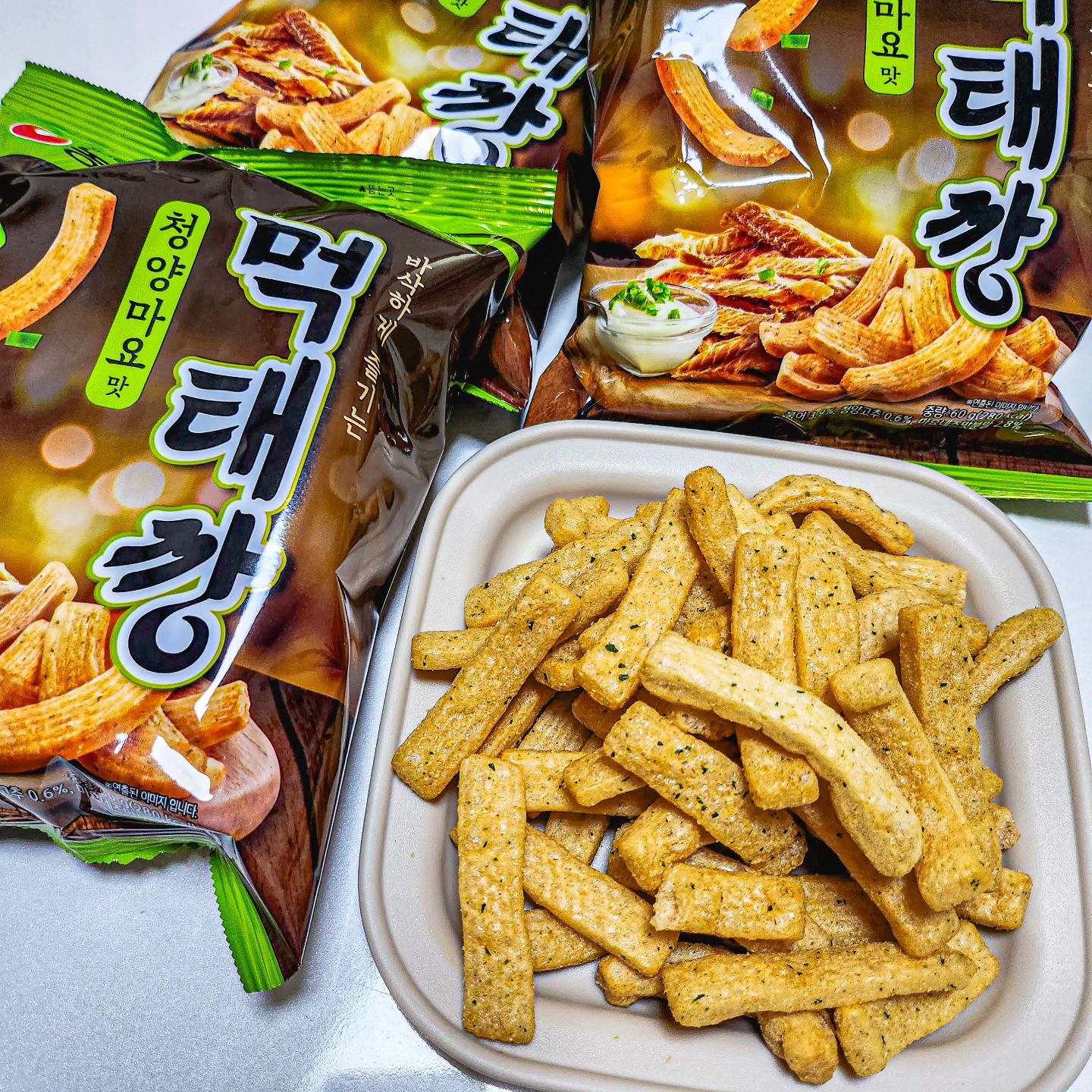 #광고
요즘 난리났다는 6번째 깡시리즈  먹태깡을 드디어 먹어봤어요'◡'
봉지를 뜯자마자 풍기는 냄새 때문에 '아 이건 맥주안주다'라고 생각했지만
맥주를 사오지 않는 대참사가 일어나 어쩔 수 없이 과자만 뇸뇸
진짜 북어가 함유되어 있어서 한 입 먹자마자 그 짭조롬한 감칠맛이 대.박👍
뒷맛은 청양고추의 매콤함도 은근히 올라와서 계속 손이 가는 맛!!!
오징어집, 자갈치에 이어 최애 과자리스트에 먹태깡도 들어와버림🧡
저처럼 해산물 과자 좋아하시는 분들은 입에 딱 맞을 것 같아요ㅎㅎ
.
.
#농심 #먹태깡 #깡스낵 #먹태깡청양마요맛 #신상과자 #맥주안주 #편의점신상