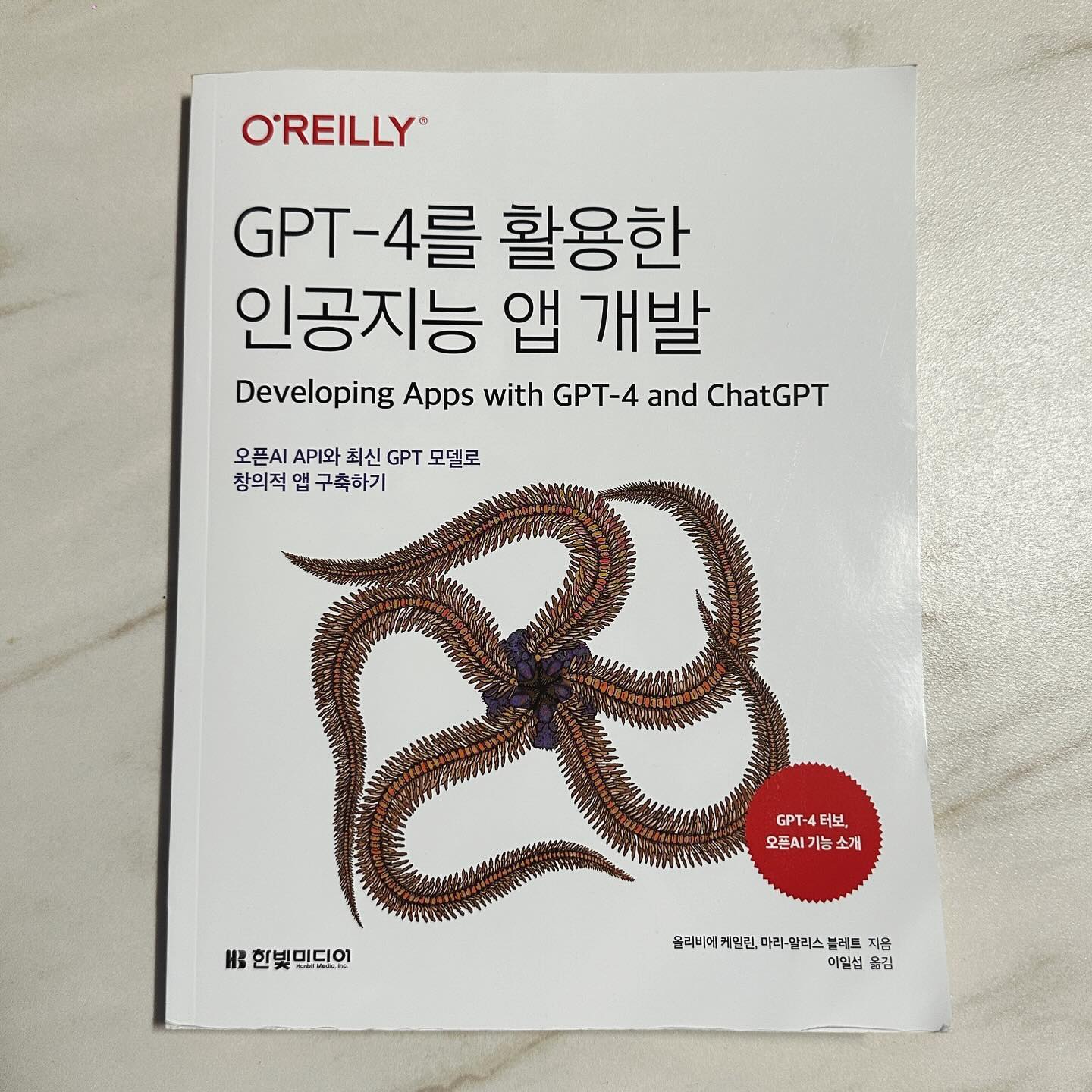 #협찬 #한빛출판사 #gpt-4를 활용한 인공지능앱개발
GPT-4를 활용한 인공지능 앱 개발
(오픈AI API와 최신 GPT 모델로 창의적 앱 구축하기)
저자올리비에 케일린, 마리-알리스 블레트
출판 한빛미디어2023.12.27.
요즘 핫한 chat GPT 많이들 사용하고 계신가요?
저는 이번 한빛미디어 책 ’GPT-4를 활용한 인공지능 앱 개발‘을 통해
GPT-4를 활용하여 인공지능 앱을 개발하는 방법에 대해 알아보았습니다. 📘🚀
AI가 발전할때마다 내 입지에 대해 더 생각해보는 것 같은데요. 그럴때 일수록 약해지지 말고,
더 활용법을 공부해야지~하는 마음이 불타는것 같습니다. 이때 함께 하면 좋은 이번 책!
🌟 주요 내용
LLM 활용: 이 책은 최신 언어 모델인 LLM(Large Language Model)을 활용한 앱 구축 방법을 소개합니다.
🌟책의 구성: GPT-4와 ChatGPT의 기본 개념부터 시작하여, 인공지능 환경, API 사용법, 소프트웨어 아키텍처 원칙, 프롬프트 디자인, 프롬프트 엔지니어링 및 파인튜닝 기법 등을 다룹니다. 마지막 장에서는 랭체인(LangChain)과 플러그인에 대해 설명합니다. 
이때 프롬프트나 GPT에 대해 잘 모른다고 걱정하지마세요.
현재 GPT 4인상황 GPT 1부터 차근차근 설명해주니 집중이 쉬었습니다.
이때 GPT-4를 살펴봐야 하는 이유는 챗 GPT4와 챗 GPT모델이 API형태로 제공됨에 따라 개발자들이 이를 활용할 수 있게 되었는데요.
때문에 AI관한 깊은 지식이 없어도 자연어를 이해하고 응답하는 어플리케이션을 구축할 수 있습니다.
각 모델에 대한 이미지화를 통해 쉽게 어플리케이션 구축방법을 알려주니!
💻📚CHAT GPT를 통해 어플개발을 원하셨던 분들에게는 기초부터 탄탄하게 접근하는 이번 책 알아보세요!
📚특히 4.1.4에서는 프롬프트 효과 향상으로 다양한 상황에서 프롬프트 작성에 사용할 수 있는 팁과 요령을 제공하니 어플리케이션 개발외에도 GPT를 활용하시는 분들이라면 누구나 도움이 될 만한 정보도 있었습니다.