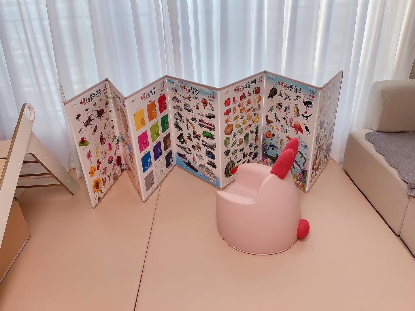 훈민출판사에서 엄마랑 벽그림 프리미엄 병풍
체험단으로 선정해주셔서 크리스마스 선물처럼
저희집에 오게 된 병풍이예요 .ᐟ

저희집엔 이미 27개월인 딸이 살고있어요 :)
그런데 왜 신청했냐구요?
이유를 알려드릴께요🤍

𝟙.포스터는 지저분하나 아이에게 일상생활에서
꾸준히 노출할 컨텐츠가 필요했어요 .ᐟ

𝟚.말이 트이긴 했으나 다양한 단어를 원활하게 
사용하진 못해서 단어익힘용으로 참 좋을거같았거든요

𝟛.무엇보다 훈민출판사 제품이여서 너무 탐났어요
아이가 단어카드와 캥거루 자연주머니 소전집을 
돌 전부터 따로 구매해서 사용하고 있었거든요🩷

아침에 일어나자마자 신나게 달려와서
병풍의 동물 페이지를 보고 있는 모습이예요🤍
동물𝟙.𝟚 페이지를 동물농장이라고 부른답니다
고래그림을 한번 보고~ 고래책도 한번 읽어보고요

캥거루자연주머니도 
엄마랑 프리미엄 병풍도
엄마랑 낱말카드도 
당연히 세이펜 지원도 되고요 

캥거루 자연주머니는 
특히 자세히 설명할 수 있는데 
(1년이상 꾸준히 본 책)
음원도 정말정말 좋고
전권 얇은 보드북 재질에
가격도 너무 착한데!!
오늘은 병풍을 소개해야하니
이정도로만 할게요☺️

실사로 이루어져있어서 아이들의 인지발달에
그림보다 훨~~씬 좋아요.
그림은 아기자기하고 귀엽지만 
실제 동물과 연결시키기까지는 어렵거든요
반면에 실사로 미리 익힌다면 그림을 보고도
쉽게 유추 할 수 있어요

안전하고 사이즈가 정말 커요
키 90cm가 넘은 저희 아이에게도 정말 큰 책이 되어줘요 
병풍 사실 엄마들 티비볼때 갓난아기들 주변에 걸쳐
아이들에게 티비 노출을 안하는 용도로 쓰시는분들
정~말 많으시죠? 저또한 그랫구요
사이즈 정말 충분해요 무엇보다 펼치면 정말 넓어요
조금 더 일찍 접했다면 이미 구매해서 썼을거같아요ㅎㅎ
그리고 모서리부분은 원단바이어스로 마감되어있어요
뾰족한부분 있을 수가 없구 
접히는 부분도 원단테이프가 붙어있더라구요
아이가 위로 넘어져도 안심! 입니다

그리고 완성품으로 와서 거울만 붙혀주면 끝 .ᐟ
너무 간편해요 엄마표 DIY 너무 귀찮아요

재밌게 놀며 단어도 익히고 인지에 불을 붙혀줄
엄마랑 벽그림❤️ 완전 성공입니다 .ᐟ

[본 후기는 제품을 업체에서 무상지원받아 작성된 후기입니다]

#훈민출판사 #엄마랑벽그림 #캥거루자연주머니 #세이펜