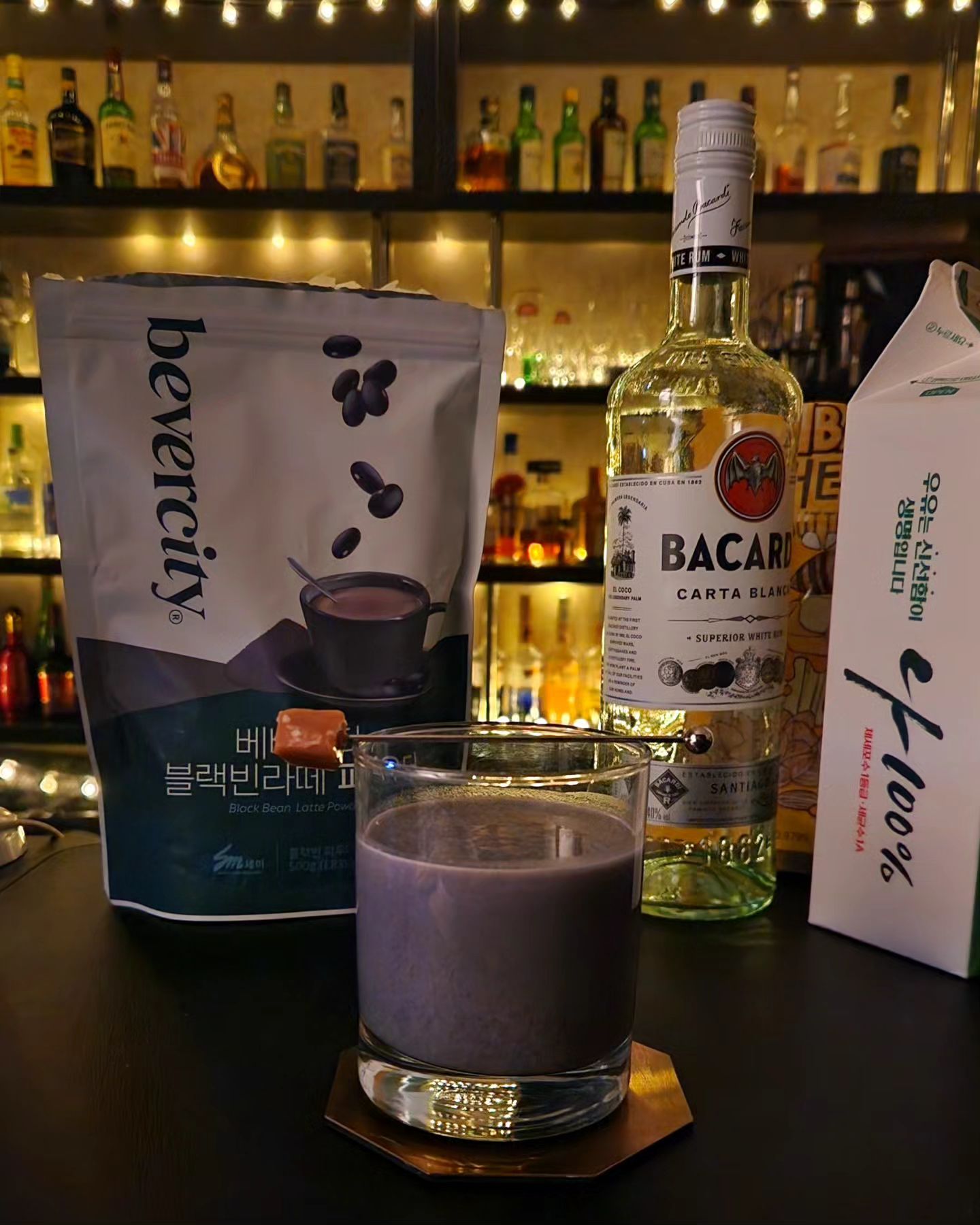 #협찬 #베버시티 블랙빈라떼 파우더

휘게-K
-  베버시티 블랙빈라떼 파우더 4 Tsp
-  Hot Milk 2 oz
-  White Rum 1 oz
Garnish : Muddled Honey Butter Almond & Caramel

어릴 적 검은콩 우유를 엄청 좋아했습니다. 근데 요즘은 우유에 넣기만 해도 그 맛이 나게끔 하는 파우더가 있다고 해서 가장 무난한 잔에, 정말 간단한 레시피로 만들어봤습니다.

2018년 월드클래스에서 Top10에 올랐던 르챔버 양효준바텐더님이 만들어낸 ‘휘게23’을 변형해서 블랙빈 휘게를 만들어봤습니다. 휘게는 덴마크어로 ‘소박하고 여유로운 시간, 소소한 안락함’이라는 뜻인데, 제가 요즘 바쁘게 사는 데 초등학생 때 즐겨먹었던 검은콩우유 맛으로 짧게나마 휘게를 느끼려고 했나 봅니다. 
블랙빈라떼 파우더와 따뜻한 우유를 섞고 휘핑기로 거품까지 조금 내줍니다. 그리고 우유의 반정도 양의 럼을 넣고 섞어줬습니다. 보드카보다 럼이 훨씬 어울려서 놀랐는데, 베이스가 되는 요소의 달달함과는 달리 술향에서 느껴지는 또다른 당도가 있는데, 그것까지 잘 어울렸습니다. 약간 Y축과 Z축 같은 느낌??

양효준바텐더님이 칵테일을 꾸밀 때 허니버터아몬드를 으깨서 꾸미고, 카라멜을 픽으로 꽃아 칵테일을 저어가며 입맛에 맞게 당도를 조절하게끔 하는 재밌는 연출이 있어 따라해봤습니다.

#세미기업 #베버시티마켓 #칵테일레시피 #칵테일변형 #칵테일스타그램 #홈텐딩 #홈카페 #혼술스타그램 #바리스타 #블랙빈라떼 #카페음료 #검은콩우유 #양효준바텐더 #휘게23 #월드클래스 #blackbeanmilk #beanmilk
#bevercitymarket #homecafe #hometending #barista #cocktailrecipe #milkcocktail #rumcocktail