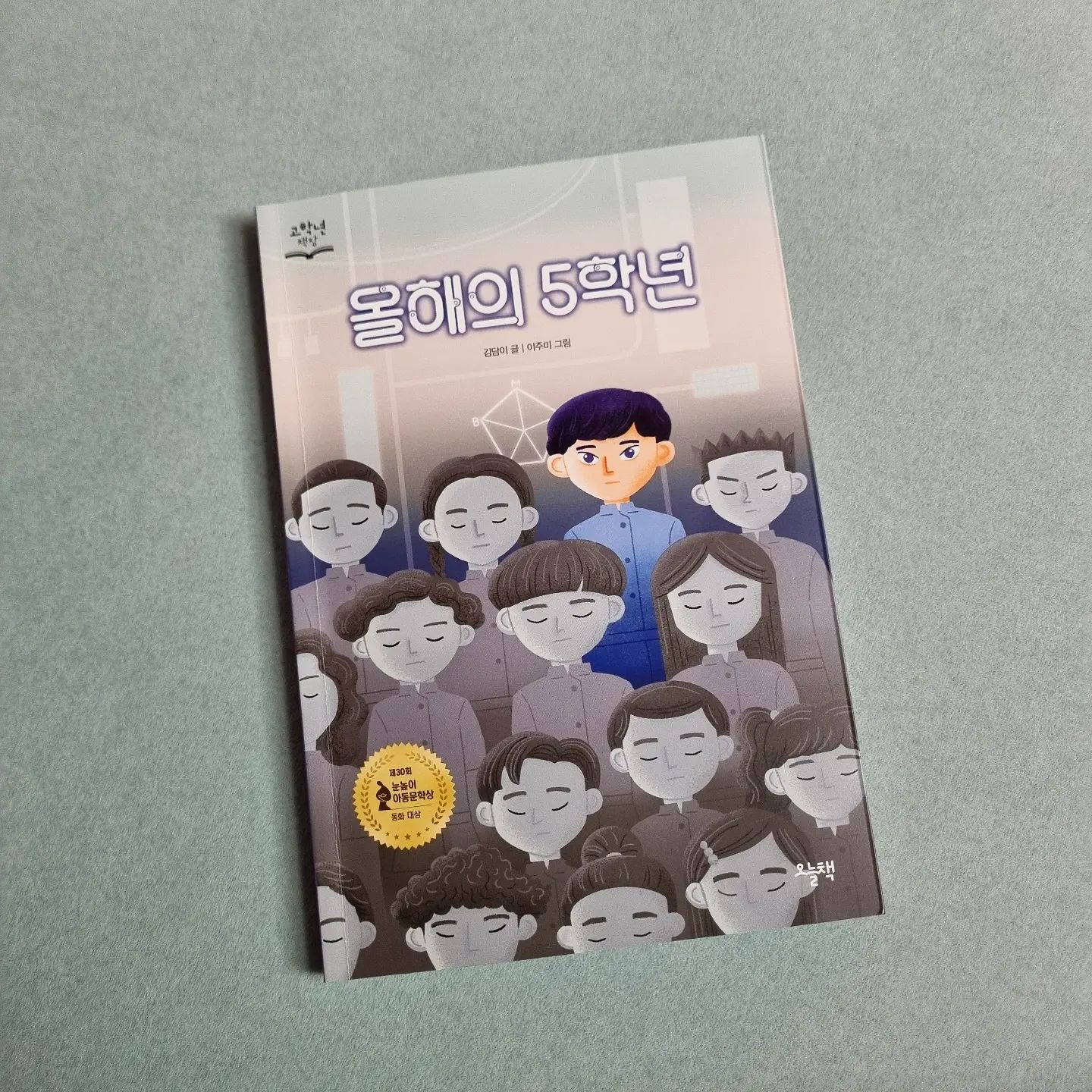 #까똑맘 #협찬 

"사랑아, 나는 내년에 꼭 6학년이 되려고 해!" 

2052년, 뇌바구미 바이러스 전염병이 퍼져 1년 사이에 전체 아이들 가운데 10분의 1이 죽고, 살아남은 아이들에겐 경계성 지능 장애가 발생해 지능 지수가 70까지 떨어졌어요. 

이 때문에 국가는 아이들의 뇌를 관리하고, 복제인간 프로젝트를 실행해 가장 우수한 아이를 올해의 소년 소녀로 선발해요. 

올해의 소년 소녀는 같은 학년의 표준이 되어 일반 아이들과 함께 생활하게 되는데, 올해의 5학년인 다겸이는 사랑이라는 여자친구까지 있는 핵인싸였답니다. 

하지만 같은 반 친구가 다겸이가 올해의 5학년이란 사실을 알게되었고, 학교에 소문이 퍼지죠. 

하루 아침에 친구들과 선생님들까지 모두 다겸이에게 등을 돌리고, 여자친구마저 다겸이를 멀리하게 돼요.

결국 올해의 5학년인 다겸이의 학습 능력과 신체 능력 시험 결과가 지난 표준에 미치지 못하는 상황이 발생하고, 센터에선 다겸이를 실패작이라며 사회에서 격리하려고 해요. 

과연 다겸이는 6학년이 될 수 있을까요? 

"길고양이도 이름을 지어 주는데 왜 사람에게 이름이 없어? 이제부터 나는 너를 시온이라고 부를 거야." 

소년11호는 이름이 없었어요. 복제인간 중 올해의 소년/소녀만이 이름을 가질 수 있었거든요. 

하지만 여름이는 소년 11호에게 시온이란 이름을 지어주고 첫번째 친구가 되어줘요.
그저 이름만 생겼을 뿐인데 많은게 변하게 되었답니다. 

이를 보며 이름이 얼마나 소중한 것인지, 이름을 불러주는 것의 의미를 생각하게 하네요. 

제 30회 눈높이 아동문학상 동화 대상을 받은 작품이라 아동 동화이지만 어른들이 읽어도 참 좋은 내용이었어요. 엄마와 아이가 함께 읽고 이야기 나누면 더 좋을 것 같아요. 

📚 지금 알라딘에서 올해의 5학년 등 <23년도 눈높이문학상 수상작 포함 2만원 이상 구매시 동물 파우치 필통> 이벤트를 하고 있어 더 좋네요. 

onulbook_official

#오늘책 #눈높이문학상 #그림동화 #그림책 #독서 #추천도서 #올해의5학년 #이벤트 #책스타그램 #북스타그램 #초등추천도서 #고학년책장 #신간