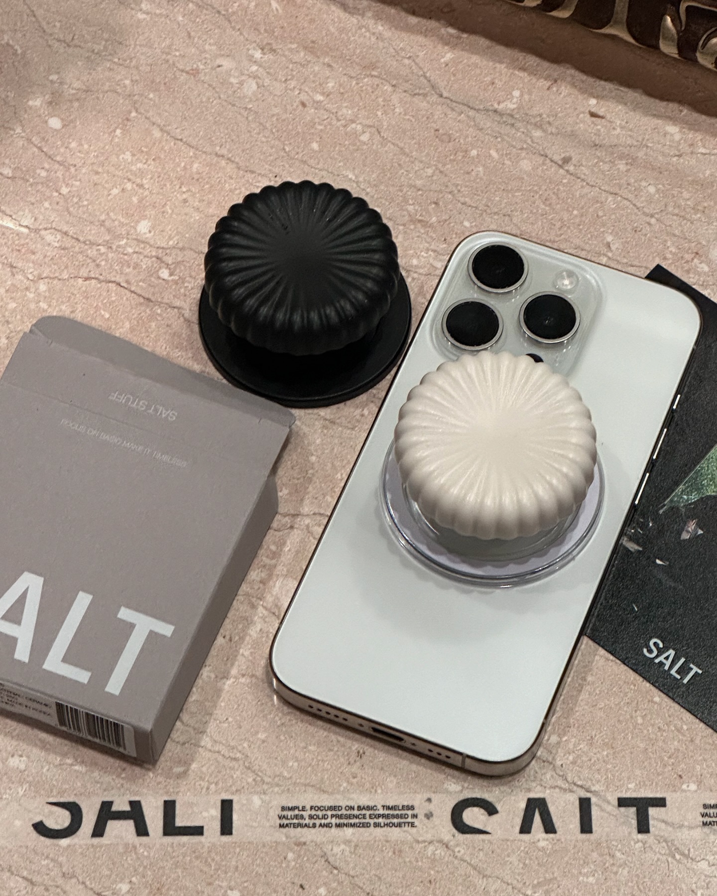 #협찬 salt.stuff_official 

그립톡은 언제부턴가 누구나 하나쯤은 붙이고 있고 소품샵에 그득하고 홍보품으로 자리잡을 정도로 흔한 아이템이 되었다.
흔한 디자인 , 값싼 모델부터 고가의 제품까지 천차만별이라 고르는 일 또한 성가신 수준이다. 본래 그립톡은 핸드폰 본연의 디자인에 부속품으로 추가하여 사용함으로 과하면 실용적으로나 디자인적으로나 불필요할 수 있다. 

둘러보던중 솔트스터프에서 여러 색도 아닌 흑과 백 그 단순한 두 가지 색상, 모양 또한 원형에 주름을 담고있는 간단한 디자인이 그 독특한 질감과 색채가 오히려 더 명료하게 매력이 느껴져 구입한 후 1년동안 사용중이었다.

그 후, 내구성도 마음에 들어 눈여겨 보던중 최근, 맥세이프 까눌레 볼드 버전이 출시되어 반가운 마음에 협찬을 진행하게 되었다.
현재도 2주째 잘 사용하고있다. 
생폰 느낌을 좋아하시는 분, 본연의 느낌이 중요하다고 생각하시는 분들은 한번쯤 관심 가져볼만한 것 같다.

⚪️#솔트스터프 #SALTSTUFF #세라믹폰그립 #까눌레 #볼드