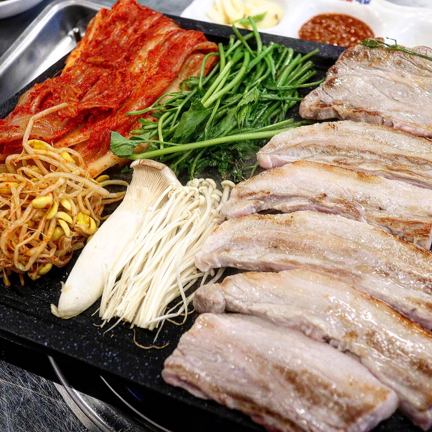 이게 옛날 한판 삼겹살의 정석이지!

#배곧맛집 #경아식당

경아식당은 부대찌개로 유명한 곳이지만,
한판 고기 세트도 구성과 가격이 좋아요🔥

강원도 고랭지 배추로 만든 묵은지가 대박!
거기다 콩나물, 미나리, 팽이 새송이버섯🍄
판에 올려주고 두툼한 삼겹살, 목살까지😆

새콤한 묵은지와 같이 참기름 촉! 찍어주면
고소, 새콤한 조합이 계속 손이가게 하고요!
같이 나오는 생와사비, 간장소스, 특제양념
까지 곁들여 먹을 다양한 소스들이 질리지
않고, 포슬포슬한 계란찜 밥생각 절로 나게
하는 두부가 커다란 된장찌개까지 완벽한
집에서 먹는 최강의 조합들이 모였달까⁉️ 

이 묵은지를 맛봤으면 볶음밥은 무조건〰️
눌러 붙게 해서 누룽지까지 만들어 먹으면
참기름 김치 김이 한데 어울러져 새콤달달
거기다 마지막 김치말이국수는 기름기를
한번에 털어주는 극약처방💊😆

고기맛도 고소하고 딱 집에서 먹는 그맛!
3인이 먹기 좋은 한판 메뉴가 4만원대로
각종 재료 올려먹는 고기 좋아하면 추천😋

📌경아식당 배곧점
⏰월~금 11:30 - 23:00
(16:00 - 17:00 브레이크타임)
토,일 11:30 - 23:00
📍경기 시흥시 서울대학로278번길 
19-14 배곧프라자 105호
📞0507-1403-9129
⭕️단체석, 주차, 포장, 배달, 예약
🏷️경아 묵은지 한판 41,000원
(삼겹살 300g+목살150g+모듬버섯+미나리+된장찌개)
🏷️공기밥 1,000원 x 2
🏷️볶음밥 3,000원
🏷️김치말이 물국수 5,000원

#블로그협찬받았으나인스타리뷰는내뜻 #냥꾸먹방🍴 #고기맛집 #배곧신도시맛집 #배곧신도시 #정왕동맛집 #삼겹살맛집 #먹방스타그램 #먹부림 #맛집탐방 #먹팔 #맛팔 #맛집투어