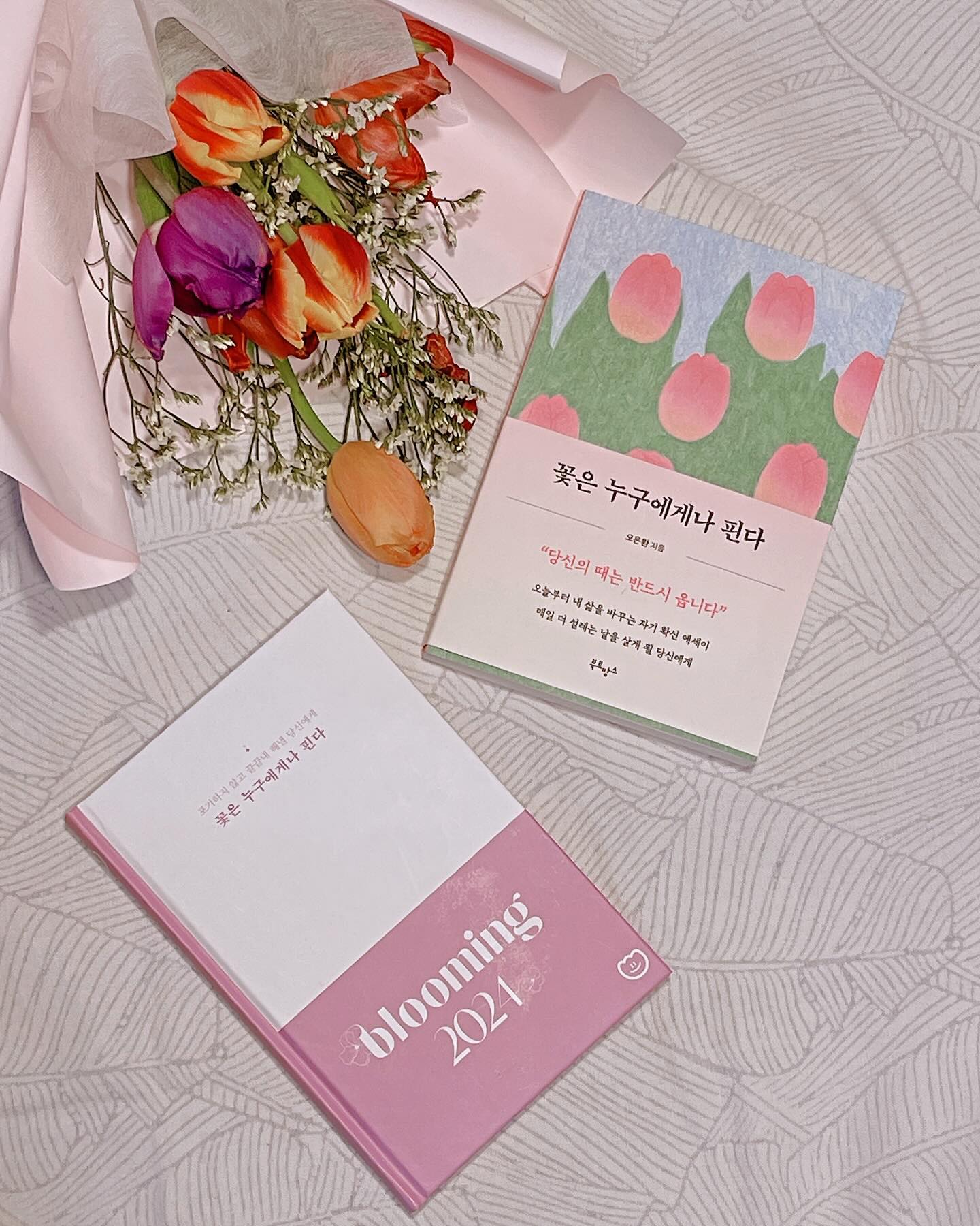 #꽃은누구에게나핀다 는 단순명료한 사실
#도서제공 #북로망스

“당신의때는반드시옵니다” 라는 자기확신 에세이

🌷인생의 꽃은 누구에게나 한 번쯤은 핀다고 해요. 당신의 때는 결국 옵니다. 너무 조급해하지 않아도 괜찮아요.

목표는 공유해야 힘을 내고 이루어진다는 선명한 믿음으로
꾸려가면 좋겠다 싶은 블루밍 노트까지 참 예쁘죠😊

기대하지 않았던 새해 정기승급에 이름을 올리고 축하를 받고
기대했던 인사평가 점수가 예상보다 낮음에 아쉬움이 있는
1월을 보내면서 일희일비하지 않으면서도
워킹맘으로서의 소양을 가꿔가고자하는 다짐을
소중하고 예쁜 책과 함께 해보고 있습니다

꽃선물을 받아온, 또 다른 축하를 받은 남편은
꽃다발 들고 온 다음 날부터 골골대고 있으니
인생이란 참 다면적인 면모를 지녔구나
생각할 수 밖에 없어져요

환경의 영향을 받을 수 밖에 없지만 휘둘리지 않고
내 마음을 가꾸고 아기자기 꾸려갈 생각에
동기부여 자연스레 되고 있구요

나에게 피어났던 꽃들이 있었다면
다음 봄의 꽃은 더 아름답고 단단하게 피어나고
또 아름답게 지는 연습을 할 수 있기를🌷

다정하고 예쁘고 소중한 책 소개해요

🏷️ _book_romance 

#꽃핀다 #오은환 #책리뷰 #블루밍노트