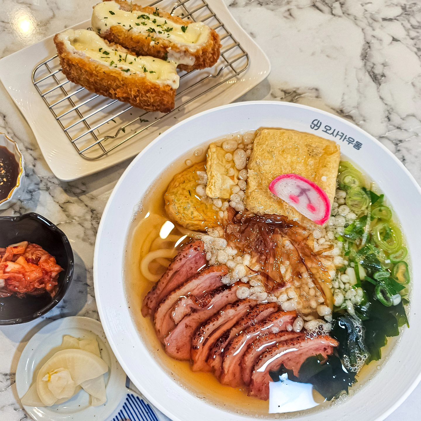 #협찬 #오사카우동본점

관악구에 배달맛집 으로 소문난 우동맛집! 오사카우동이 서울대입구에 오픈 했다하여 다녀 왔어요~ 요즘 날씨에 푸짐하고 뜨끈한 우동 한그릇 만으로도 넘 힐링이죠🥰 "오사카우동" 소개합니당 💛

🔹️몸보신 카모우동을 주문 해 보았는데 직화구이한 오리안심도 풍성하게~ 어묵, 유부, 다시마, 파까지 수북히! 이거 몸보신은 물론, 찐 해장용 입니다! 육수도 깊은맛이 나요~ 그리고 무엇보다 면발이 미쳤습니다! 제가 일본 가면 항상들리고 공항에서 출국하기 전에 먹던 츠루동탄! 그 집 면발이랑 견줄만큼 면발이 맛있어요! 부들부들~ 탱글쫄깃 그 잡채! 일본식 우동 잘하는집 많지만 항상 면발이 아쉬웠거든요.. 배달맛집이 인기가 생겨 매장까지 오픈한데는 그만한 이유가 있더라구요~ 물에빠진 오리고기 약간 거부감이 들었는데 대표메뉴라 믿고 시켜 봤어요! 오리도 쫄깃하고 진짜 몸보신 하는 기분 이었어요! 육수도 깔끔하고 깊은맛이 나요👍

🔹️사이드로 치즈 돈카츠 시켜 봤어요! 일단 두툼하고 치즈가 장난 아니에요! 제가 혼자가서 사진 찍으려고 한개 들었는데 무거워서 젓가락이 후들후들 거렸어요 ㅋㅋ 바삭함은 물론 치즈도 쫄깃하고 ~ 치즈가 장난 아니게 늘어났는데 찍어줄 사람이.. 🤣 사이드로 시킬수 있으니 추천 드려요! 왠지 이 집 튀김 다 괜찮을거 같아요. 바삭함이 달라요👍

🔹️신메뉴로 크림우동과 로제우동도 개발 중이시더라구요. 언제 출시될지 모르지만 꾸던한 크림소스에 이집 우동 면발이면 뭐.. 맛없없 일듯! 사장님이 요리에 대한 열정이 남달라 보이셨어요~ 매장도 깔끔하고 태블릿으로 편하게 주문 할수 있어요! 혼밥은 물론 다인석까지! 요구르트도 함께 주시는 세심함까지~ 덮밥 요리도 인기가 좋고 가성비 좋은 세트메뉴도 있어요~ 전 이 집 면발 생각나서 조만간 또 갈꺼 같아요! 서울대입구역 면발이 다른 #오사카우동 추천 합니다🫶

🏡 오사카우동 
서울 관악구 남부순환로 1784 1층

☎️ 전화번호 
0507-1336-9588

🍱 주문한 메뉴 
몸보신 카모우동(오리안심) 12,000원
통모짜 치즈 돈까스(2p) 5,900원

⏰️ 영업시간 
10:00 - 22:00

#서울대입구역맛집 #봉천동맛집 #봉천역맛집 #서울대입구일식 #서울우동맛집 #서울우동 #우동전문점 #서울대역맛집 #서울대입구데이트 #서울대입구덮밥 #덮밥맛집 #일식맛집 #우동맛집 #서울맛집추천 #서울일식맛집 #봉천맛집 #서울대입구우동 #봉천동배달맛집 #일본식우동