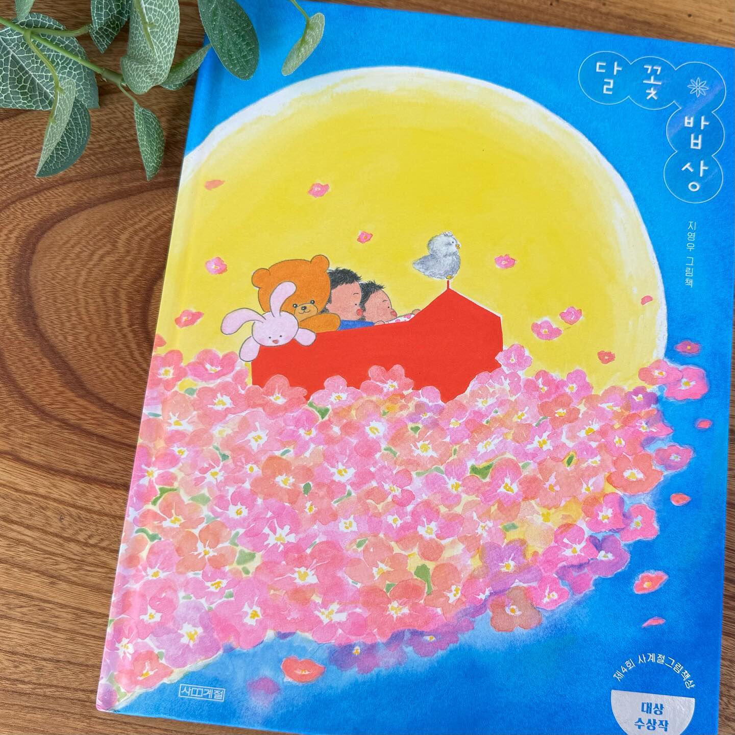 📒달꽃 밥상
▪️지음 : 지영우
▪️출판 : 사계절 출판사

할머니의 푸근한 사랑과 정을 담은 밥상을 추억하는 아이의 이야기. 달빛처럼 포근하고 꽃잎처럼 알록달록 향기마저 일품인 할머니의 정성 가득한 밥상은 할머니를 그리워하는 모든 이들에게 좋은 추억을 되살려주기에 제격인 책이다.

노오란 보름달과 아기자기하고 귀여운 그림체에 반해서 이 책이 가을에 읽기 딱 좋겠다란 생각을 하며 읽었다.
더 이상 맛있는 밥상을 차릴 수 없게 된 할머니, 그리고 그것이 속상한 아이.

이 가족들의 아픈 상황이 코 끝이 찡해지고 마음이 아리기도 하지만, 그 속에서 사랑하는 이와의 추억을 행복하게 되새기며 따뜻한 온기를 불어주는 포근한 내용이다.

“우리 아기들 왔구나!”
“배고프지? 얼른 밥 먹자!”

꽃잎 한 소쿠리로 밥을 짓고, 노오란 달 한 그릇 떠서 전을 부치는 할머니의 밥상이 너무 맛있어 보인다.

내 두 딸들은 할머니 곁에서 자라, 그 삶 속에 할머니의 손이 닿지 않은 곳이 없다. 그래서일까? 나는 이렇게 할머니가 등장하는 책을 보면 아이들과 꼭 읽어보고 싶어진다.

근처에 사는 우리 엄마, 아이들의 할머니가 손주가 조금이라도 아푸면 한걸음에 달려와 아이가 좋아하는 음식을 차려주곤 한다.

일상 속에 “할미”가 차려주는 이 따뜻한 밥상이 당장은 소소할지라도 언젠가는 추억이 되고 고마운 밥심으로 아이들이 성장해나갈 거라 생각하니 내 마음이 뭉클해진다.

🏷️출판사로부터 도서를 제공받아 작성된 솔직한 서평입니다.
_______________________________________________
#달꽃밥상 #사계절출판사 #그림책추천 #신간소개 #할머니의사랑 #밥상 #북스타그램 #책스타그램 #서평 #도서스타그램 #그림책 #어린이그림책 #책추천