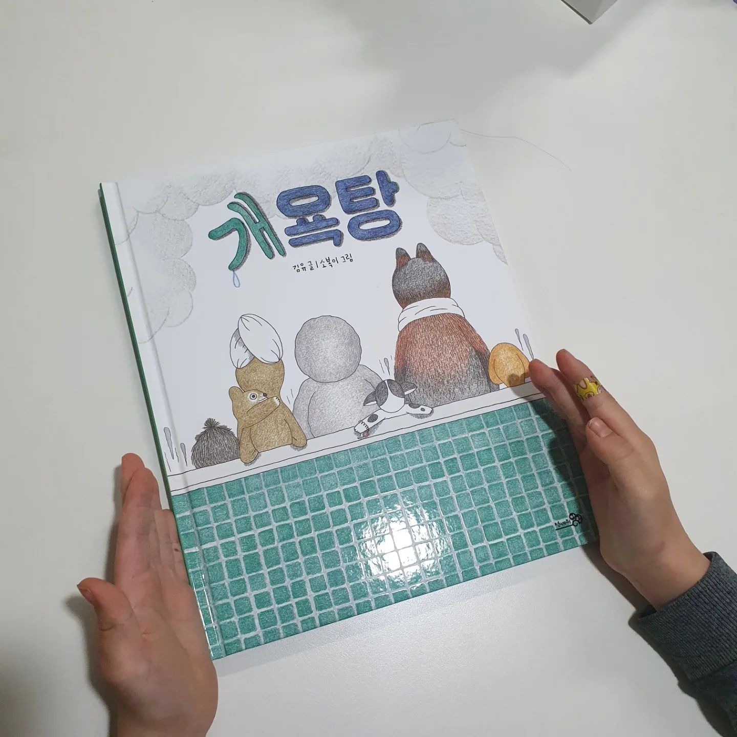 #광고 #감정그림책

사람들이 곤히 잠든밤
오픈되는 개욕탕~
오늘도 잠못든 개들이 들어서요

못생겨서 싫어
바보똥개
개들이 슬퍼보이고 화나보여요

샴퓨를 짜서 머리를 문질러보고
거울에 나쁜말을 쓰고 샤워기로 지워보아요
마음을 위로해주는듯 한결 기분이 좋아져요
개욕탕에서 몸도 마음도 반짝반짝!!!

<사자마트>, <마음버스> 읽어보셨죠
시리즈누적 10만부의 유아필독서인데요
김유,소복이 작가의 2024년 신작인 <개욕탕>이 출시되었어요

초등학생이 되면 나쁜말, 나쁜행동을 배우기도
아이가 나도 모르게 할때가 있는데요
이럴때 친구의 기분은 어떨까 생각해보고
고운말, 바른말을 쓰는 언어습관의 중요성도 알아볼수 있는 책이에요

또한 마음까지 다독여줄수 있는 책이기에
초등1학년 아이와 꼭 읽어보면 좋을듯요

#마음버스 #개욕탕 #유아필독서
#예스이십사올해의책 #사자마트 #언어감수성 
#언어습관 #생활습관 #욕 #비속어 #어휘력 #문해력 #예스24올해의책 #감정 #감정해소 #치유 #회복
#목욕탕 #개 #강아지 #마음버스 #사자마트
#천개의바람 #김유 #소복이 #올해의책
#그림책추천 #추천그림책 #마음챙김#토닥토닥