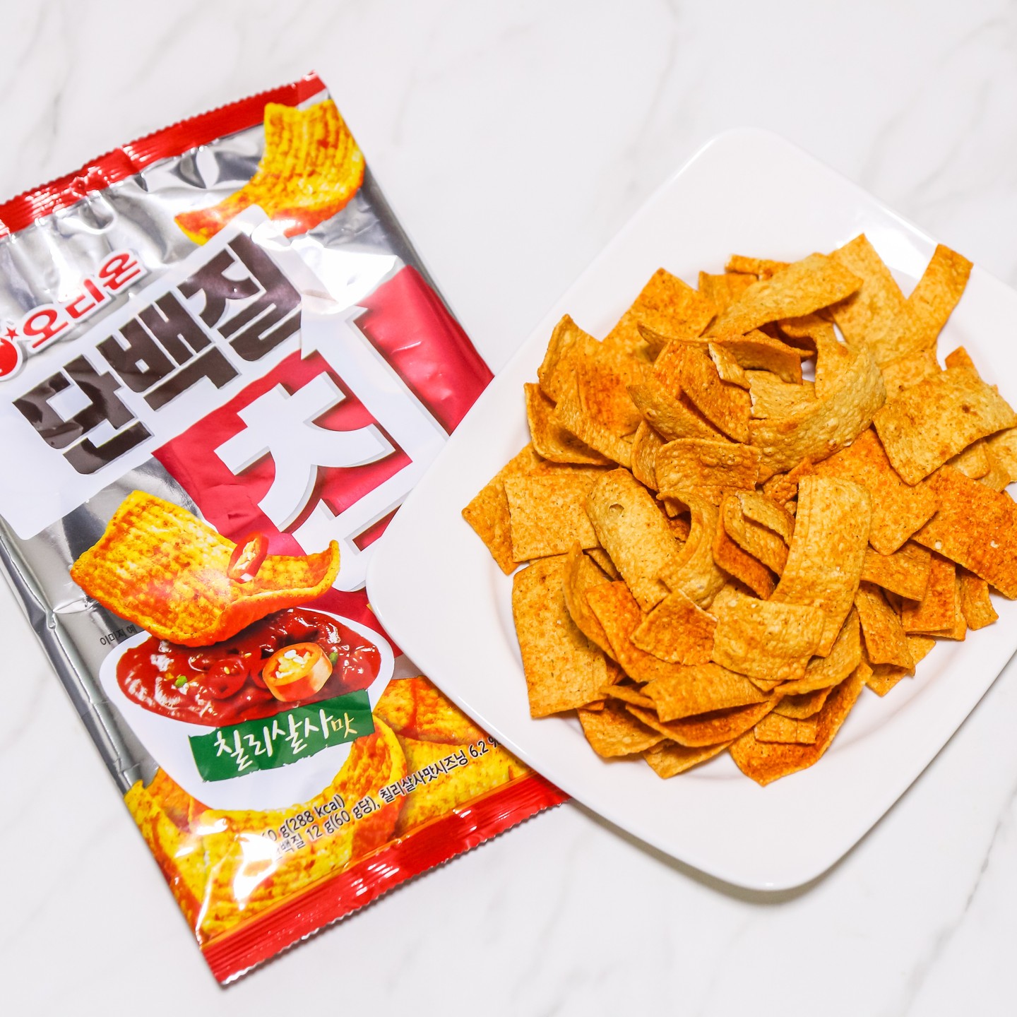 _
🥟 오리온 닥터유 단백질칩 칠리살사맛
🥟 편의점 기준 1,700원

이번에 소개 할 주전부리는 요즘 제가 푹 빠져있는 과자인 '오리온 닥터유 단백질칩 칠리살사맛' 되겠습니다. 가격은 1,700원이고 버터구이 오징어맛도 판매중인데 제 취향은 칠리살사 되겠습니다😊

사실 오리온 닥터유 시리즈의 경우 건강에 있어서는 긍정적인 이미지가 있지만, 가성비에 있어서는 최악인 과자라는 이미지가 있어 구매를 망설이기도 했는데 편의점에서 진행했던 2+1 행사가 구매를 하는데 큰 역할을 했습니다. 그때 맛을 보게되었고 그 맛에 푹 빠져 지금은 쟁여 놓고 맛을 볼 정도로 좋아하는 과자가 되었습니다🤣

단백질 함량이 상대적으로 높고 지방 함량은 낮췄기때문에 식단관리, 체중관리 등에 관심이 있는 분들이 입이 심심한데 참기 힘들 때 치팅으로 즐기기 좋은 주전부리가 안리까 생각하고 평소 짭쪼름하고 매콤한 과자를 선호하는 분들에게도 좋은 대안이 될 수 있겠습니다. 아! 그리고 맥주 안주로도 상당히 궁합이 좋으니 이 또한 참고를 하시면 좋을 것 같습니다🥰

앞서 언급을 했듯이 맛은 두가지맛을 판매중에 있으니 처음에 구매를 할때는 두가지맛을 모두 구매해서 맛보고 이후에 구매를 할때는 자신의 취향을 반영해서 선택과 집중을 하면 좋을 것 같습니다😍

가성비에 있어서는 역시 아직도 아쉬움이 조금있으며 맛, 중독성에 있어서는 합격점이 확실한 과자이기때문에 드셔보시지 않은 분들은 한번쯤 충분히 구매해서 맛 볼 만한 가치가 있지 않나 생각합니다😊
.
.
.
.
.
.
.
.
.
#오리온 #닥터유 #단백질칩 #단백질칩칠리살사맛 #편의점과자 #gs25과자 #cu과자 #과자추천 #과자스타그램 #매콤한과자 #짭짤한과자 #과자후기 #신상과자 #단백질칩칠리살사맛 #단백질칩버터구이오징어맛 #오리온과자 #닥터유과자 #오리온과자추천 #맛집블로그 #맛집블로거 #술안주 #술안주과자 #맥주안주 #맥주안주과자 #안주스타그램 #스낵